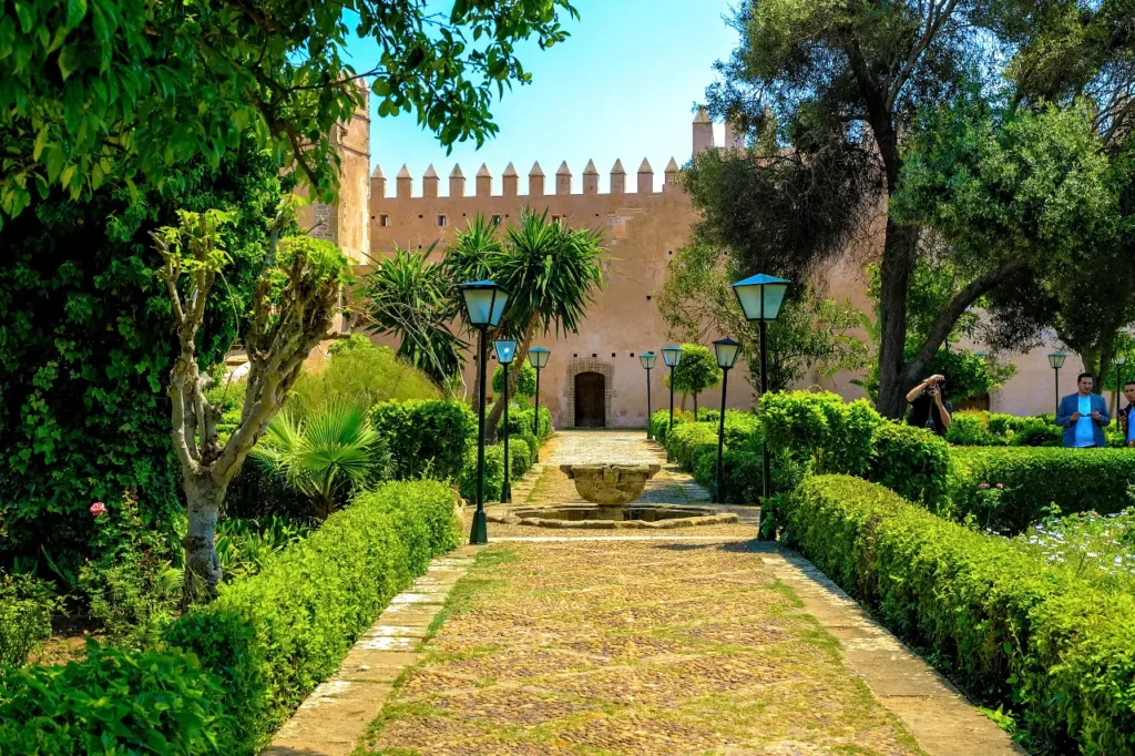 Andalusian Gardens in Rabat with trimmed hedges and a stone walkway leading to the Kasbah