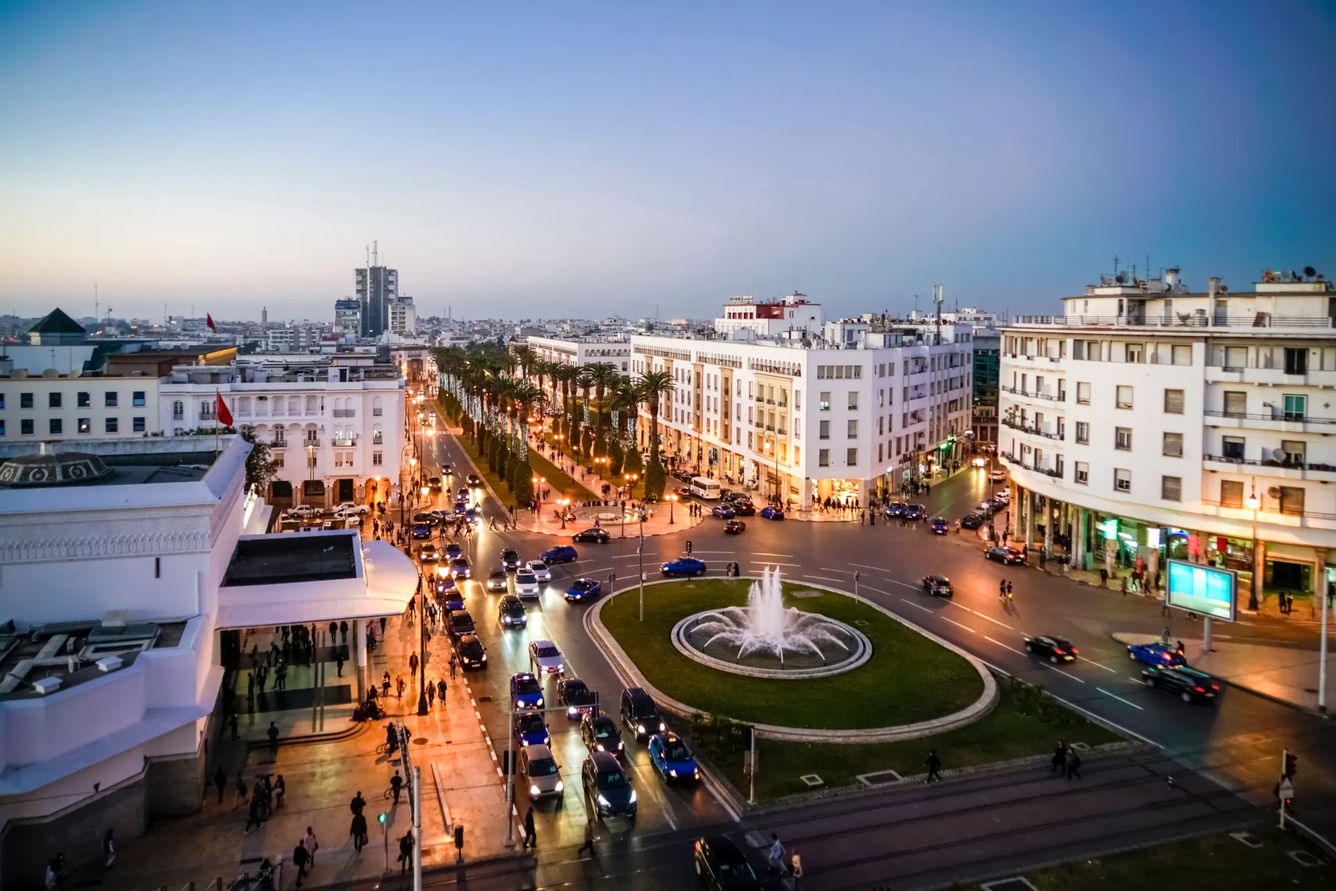 Evening view of downtown Rabat with lighted streets and central fountain