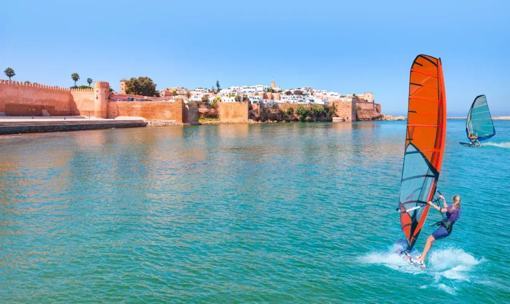 Person enjoying stand-up paddle on the Bou Regreg River with the Oudayas Kasbah in the background, Rabat Morocco