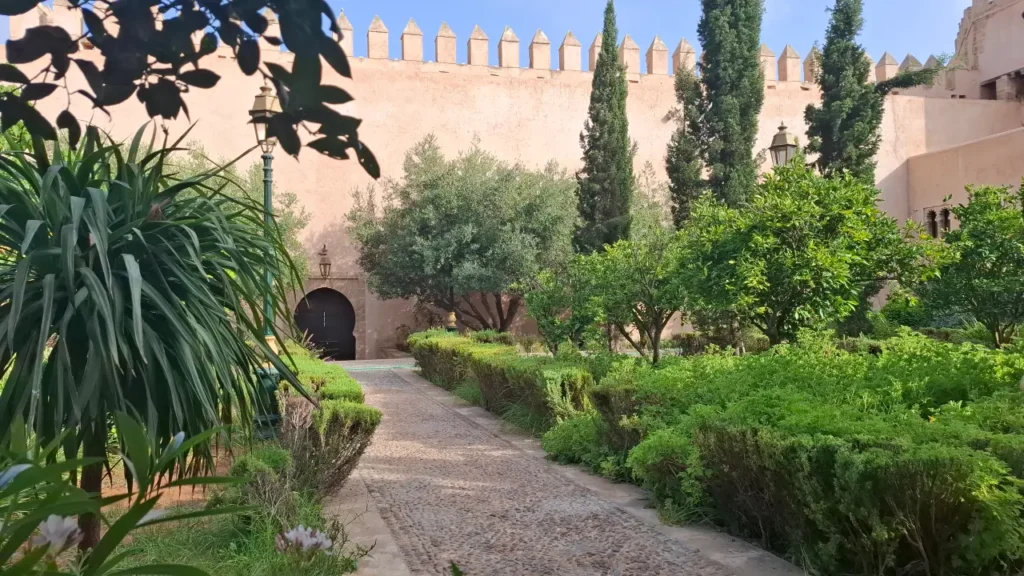 The lush green pathways and orange trees of the Andalusian Gardens underneath the historic Kasbah walls in Rabat, Morocco.