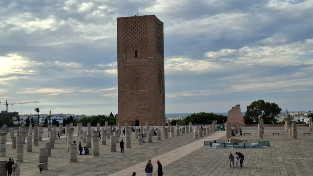 Hassan Tower esplanade in Rabat, Morocco, with broken columns, visitors and the Atlantic Ocean in the background