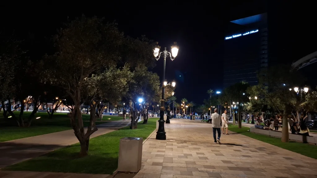 Mahaj Riad in Hay Riad, Rabat, Morocco at night with a lit pedestrian walkway and green spaces