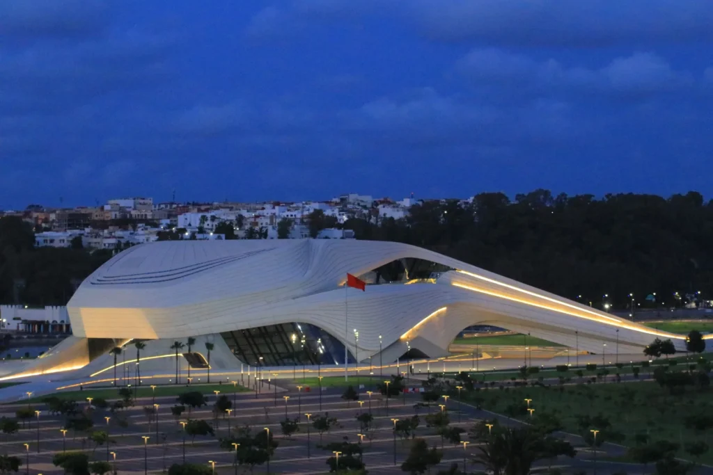 The illuminated Royal Theatre of Rabat at night, showcasing Zaha Hadid's futuristic architecture along the Bouregreg Valley in Morocco.